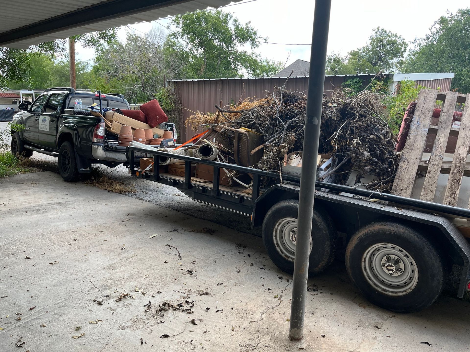 A truck is towing a trailer full of trash.