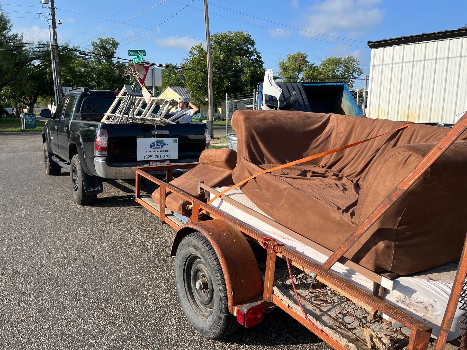 A truck is pulling a trailer with a couch on it.