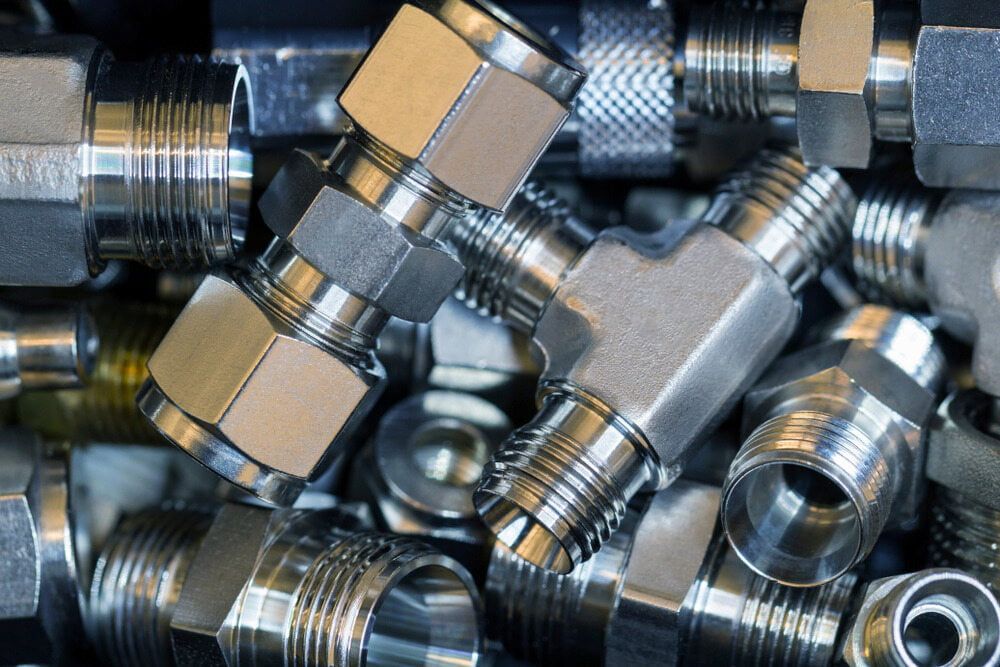 A Bunch Of Metal Fittings Are Stacked On Top Of Each Other — Hitemp Compressed Air Services in Shellharbour, NSW