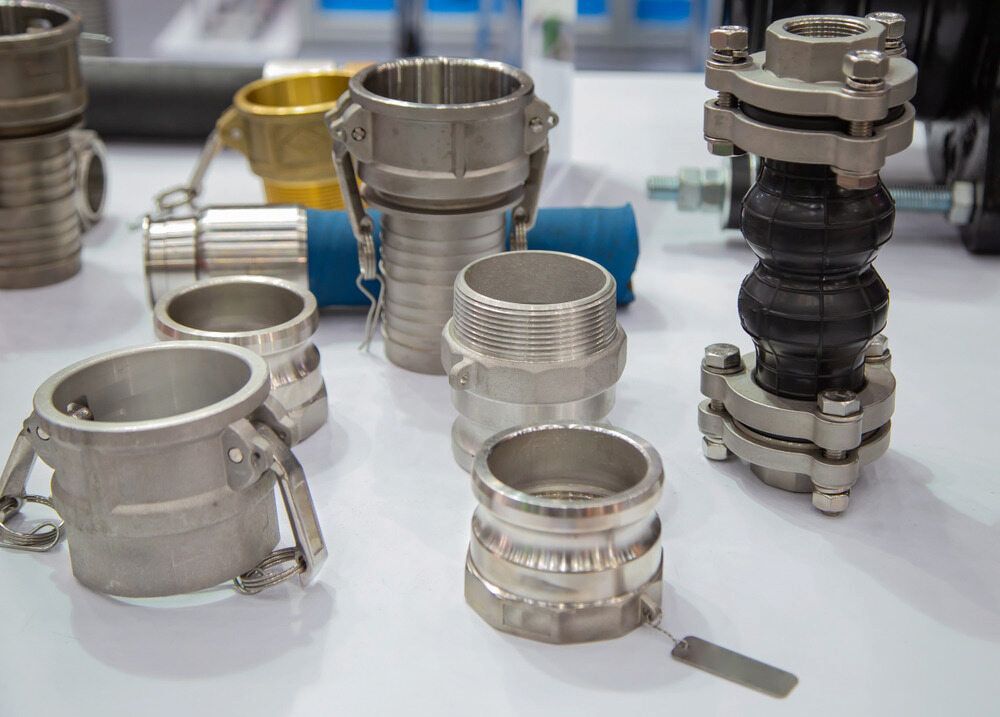 A Table Topped With A Variety Of Stainless Steel Pipe Fittings — Hitemp Compressed Air Services in Kiama, NSW