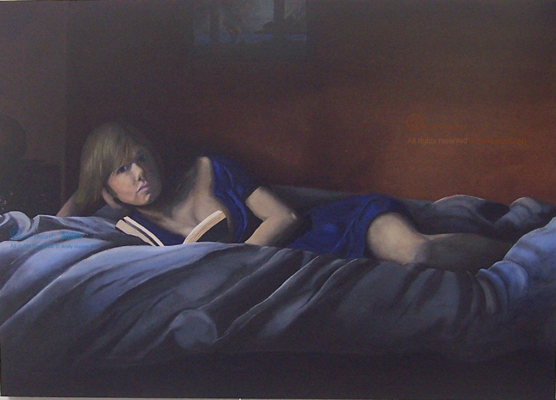 A young woman lying on a bed reading