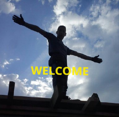 A man making a welcoming gesture with arms out wide  while silhouetted against a  blue sky