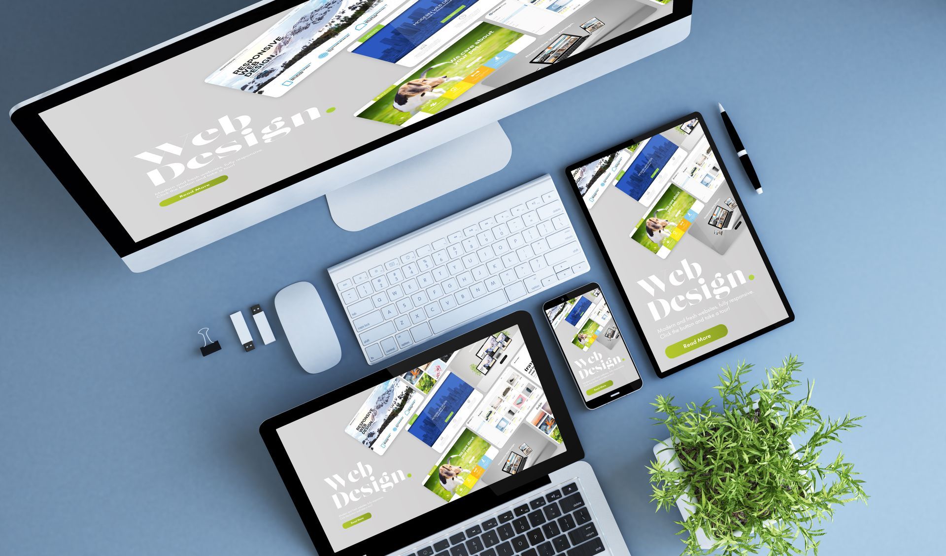 Multiple devices displaying web design layout: desktop, laptop, tablet, and smartphone on a blue surface.