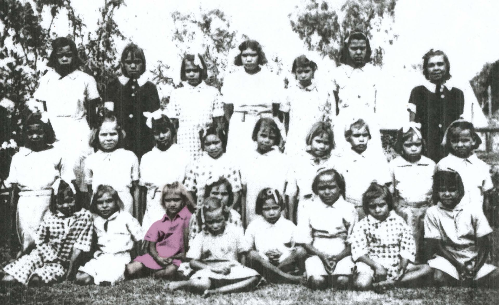 Group of school children in a black and white photo, posing outdoors.