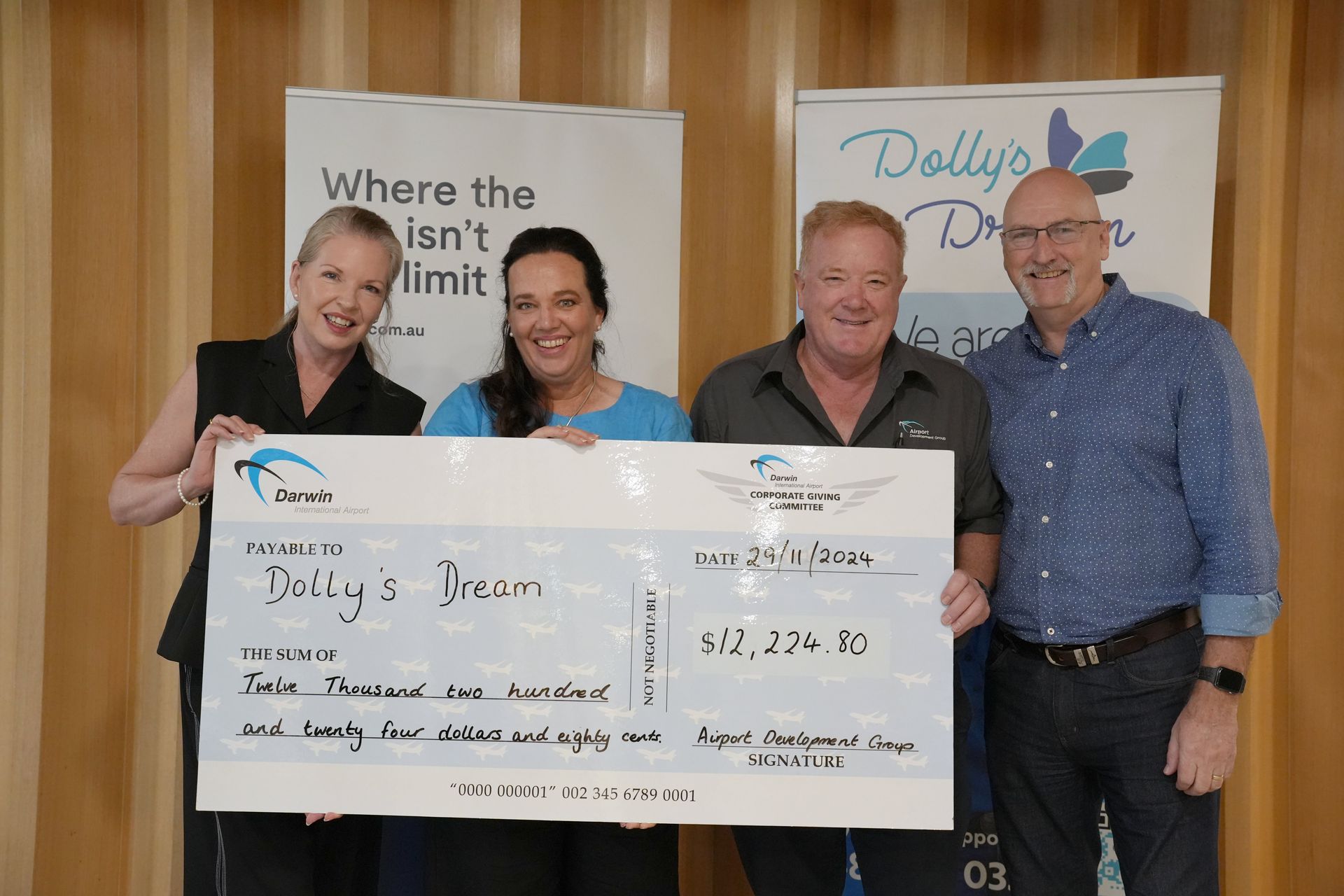 Four people posing with a grant cheque.