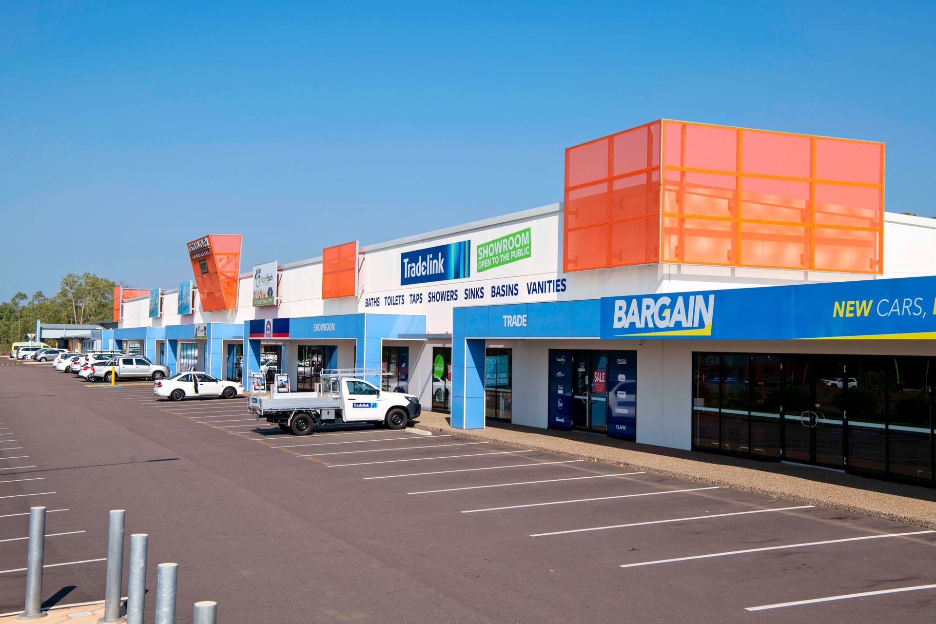 Shops at Darwin Airport Central and a parking lot with some cars