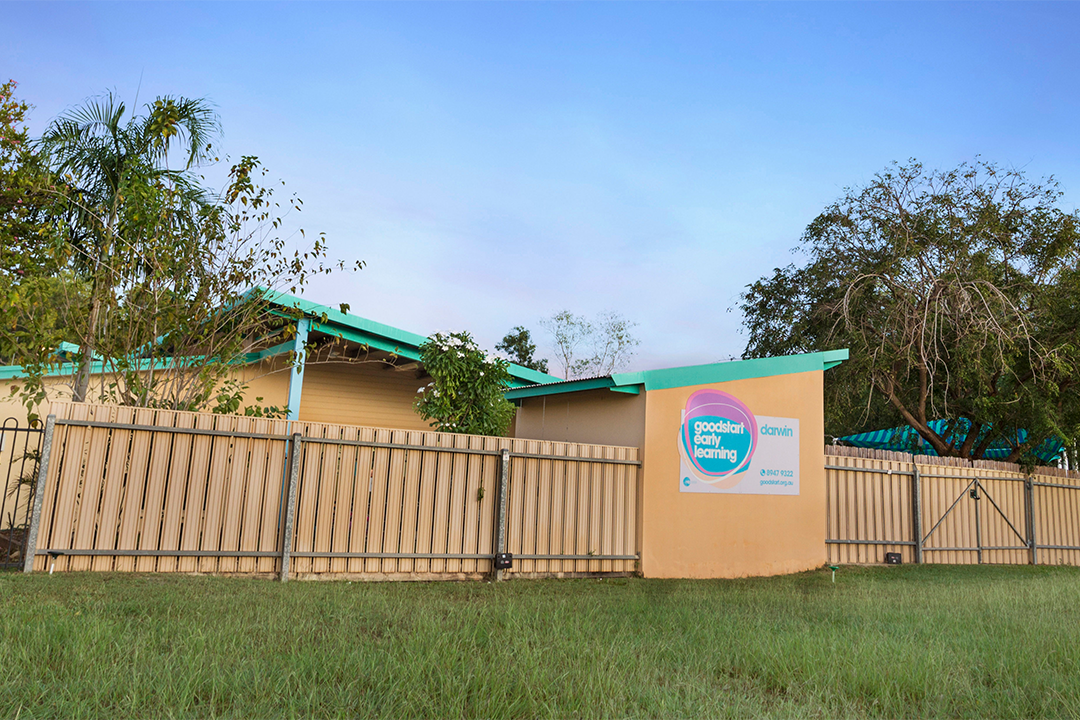 A lawn in the foreground with a childcare centre at the back.