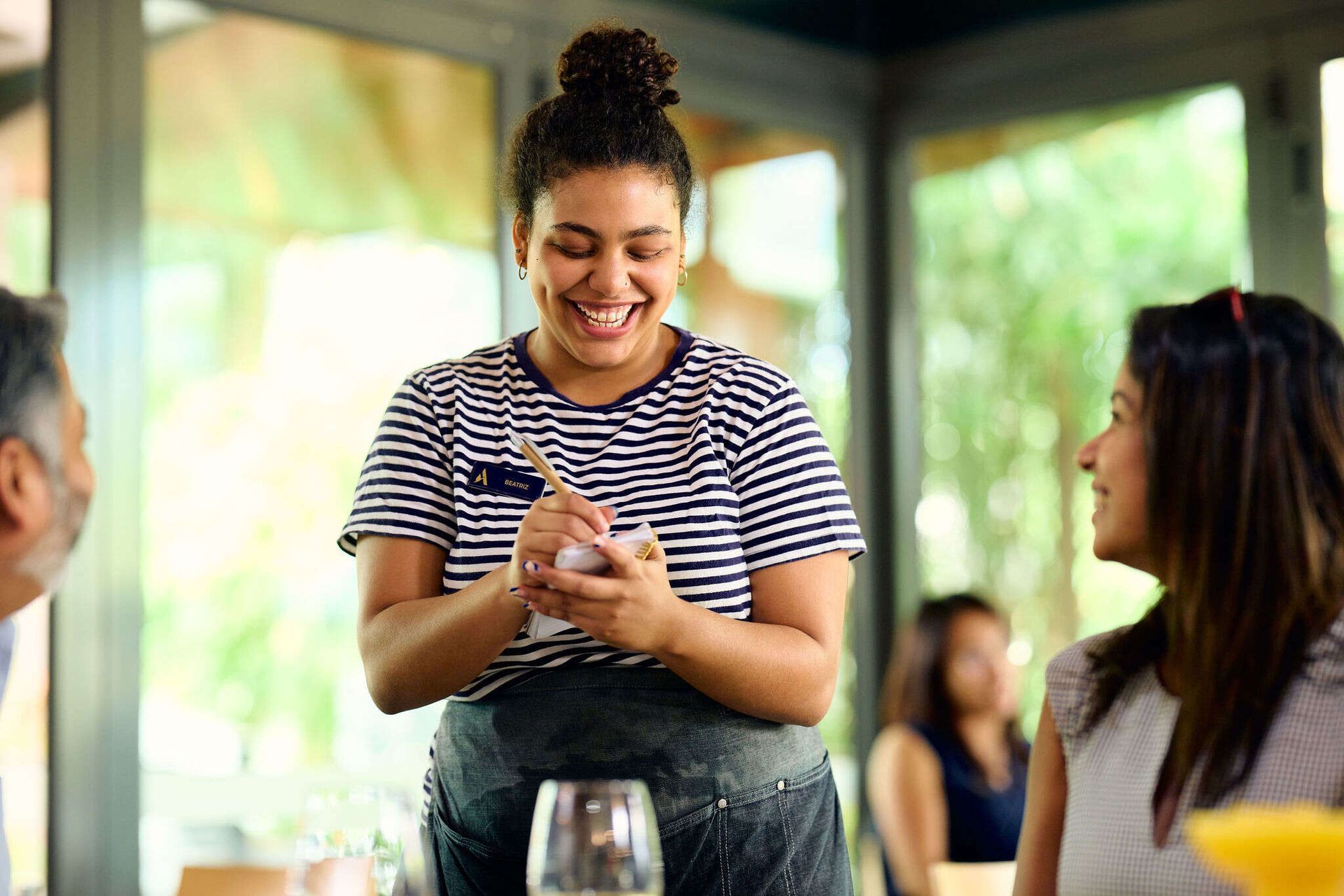 A waitress is taking a order from a customer in a restaurant.