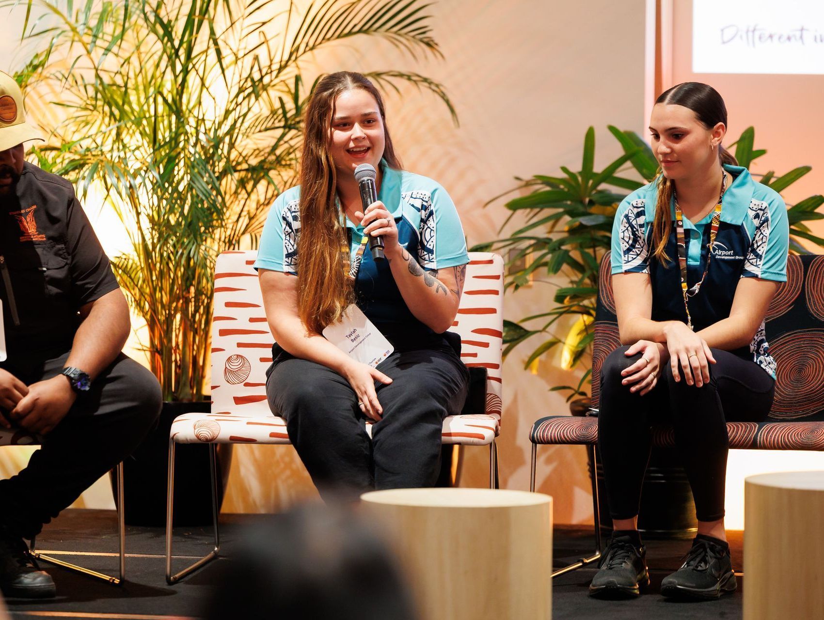 Panel discussion: Three people seated, one speaking into a microphone. 