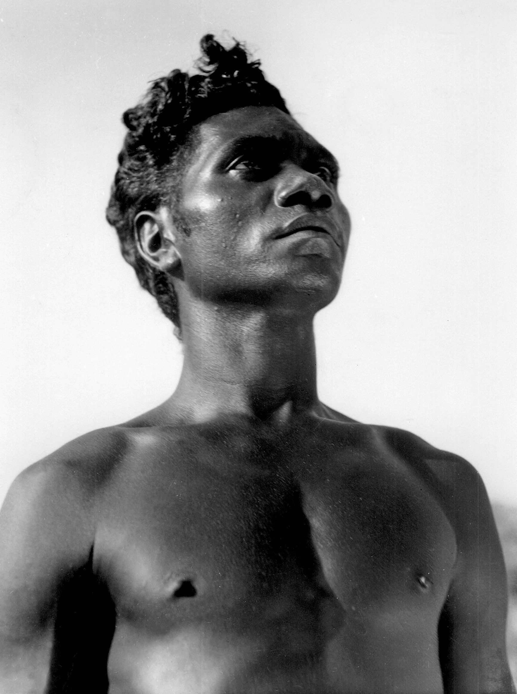 A topless man standing