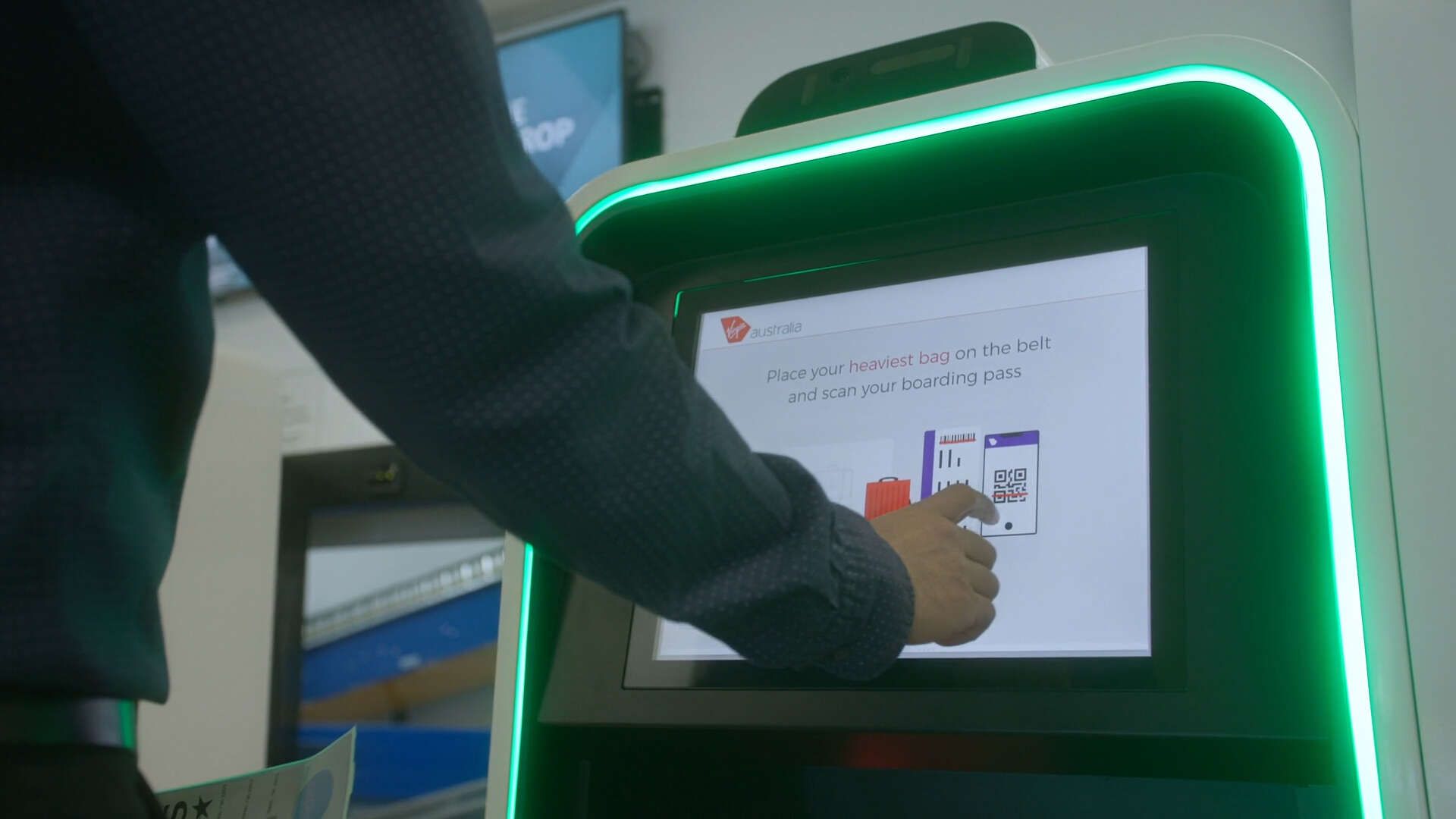 A man is using a kiosk to scan a qr code.