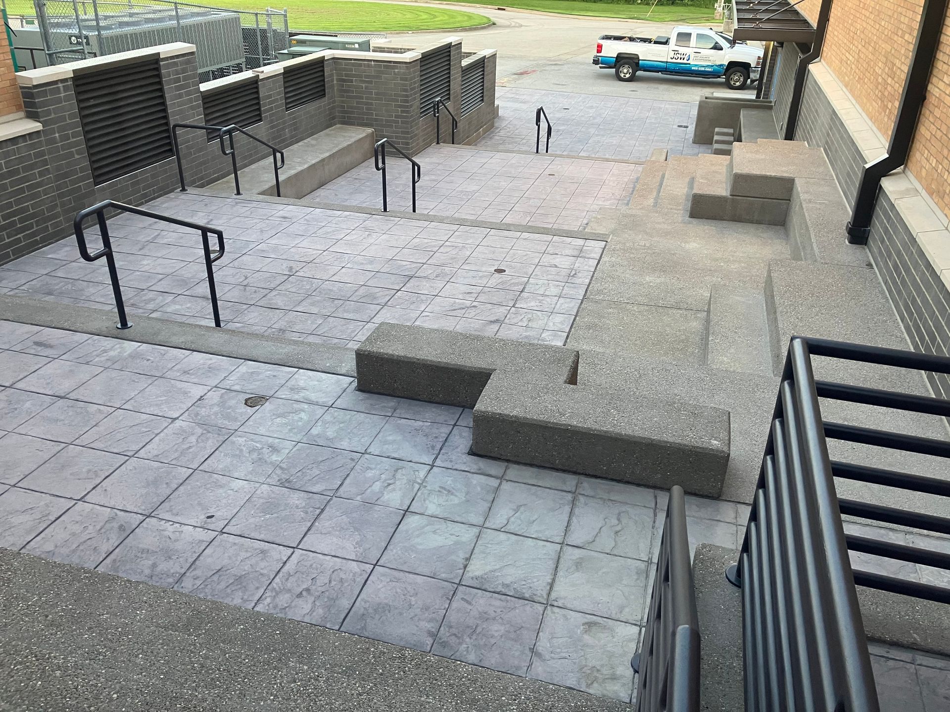 Person in orange gloves smoothing cement on a wall with a trowel.