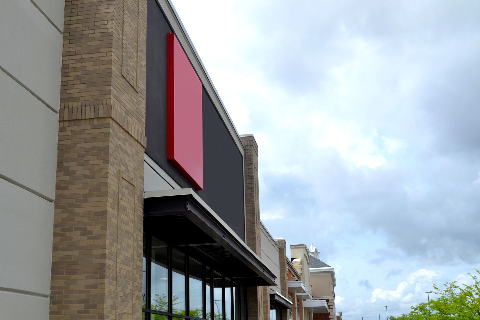Two workers applying caulk to a brick wall and door frame. One uses a caulk gun, the other smooths the caulk.