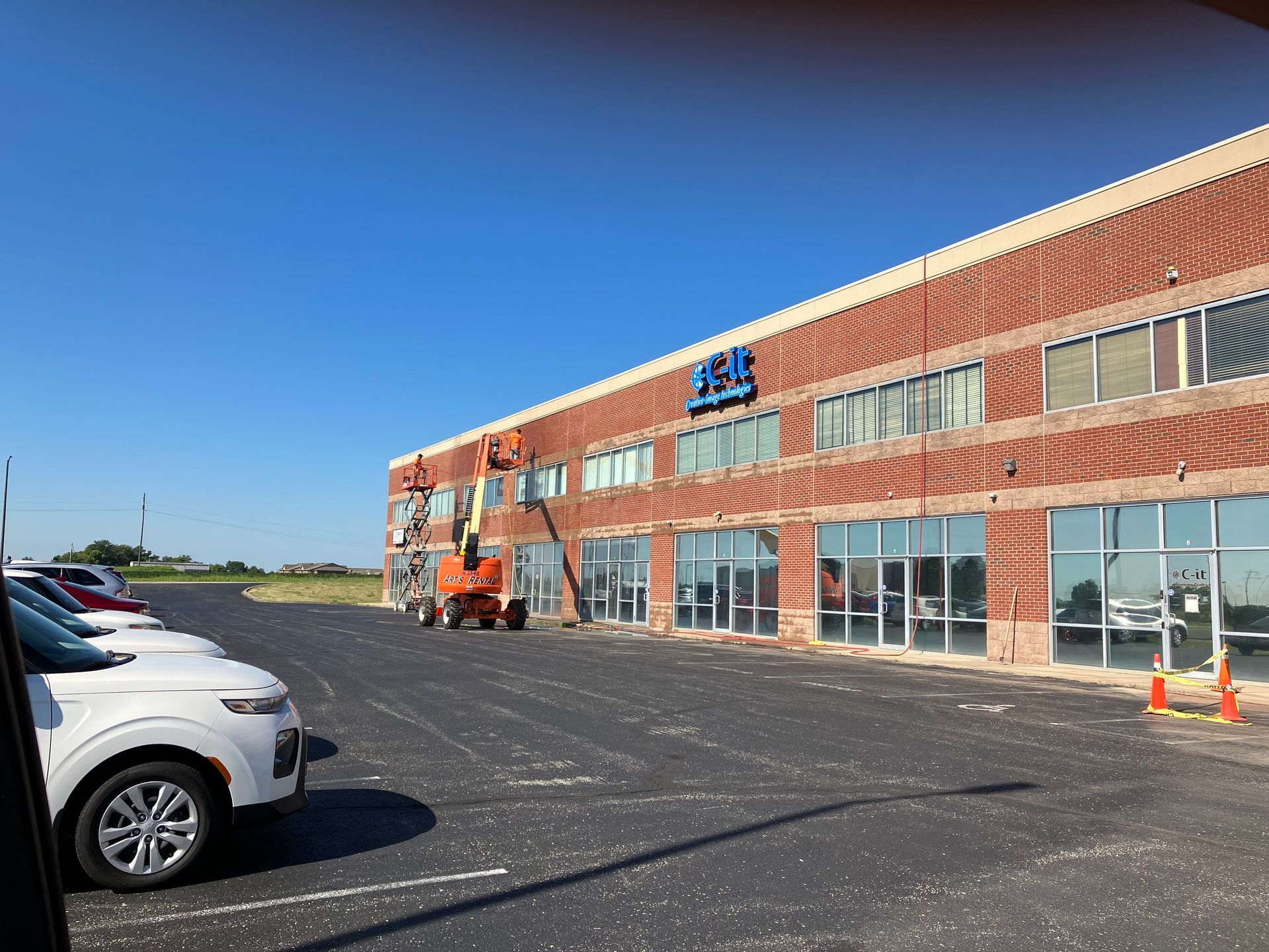 Construction worker smoothing cement with a trowel, wearing gloves, working on a roof.