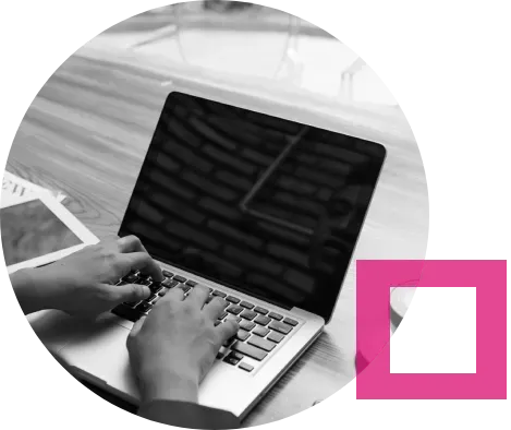 A person is typing on a laptop computer on a table.