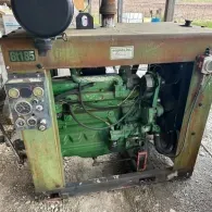 A green industrial John Deere engine mounted on a steel frame, featuring a control panel and air intake pipe.