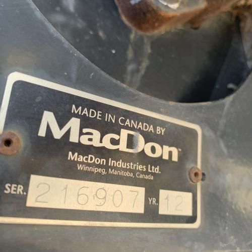 A MacDon Industries Ltd. identification plate showing serial number 216907 and year 12, made in Winnipeg, Manitoba.