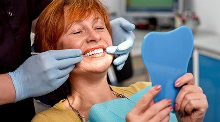 Dental And Orthodontic Treatment — Women Looking at Her Teeth in Cleveland, OH