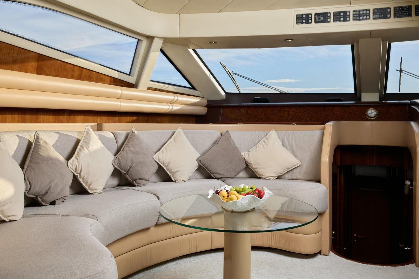 A living room with a couch and a glass table with a bowl of fruit on it