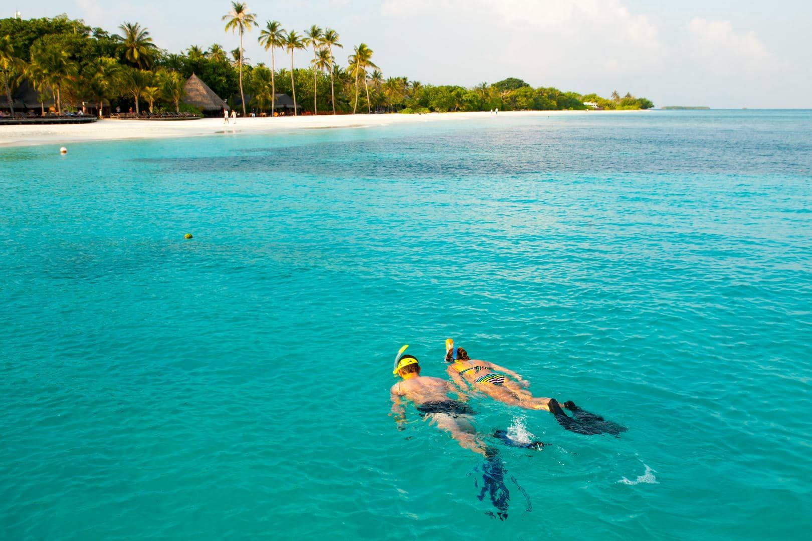 A wooden table topped with a variety of food and drinks.