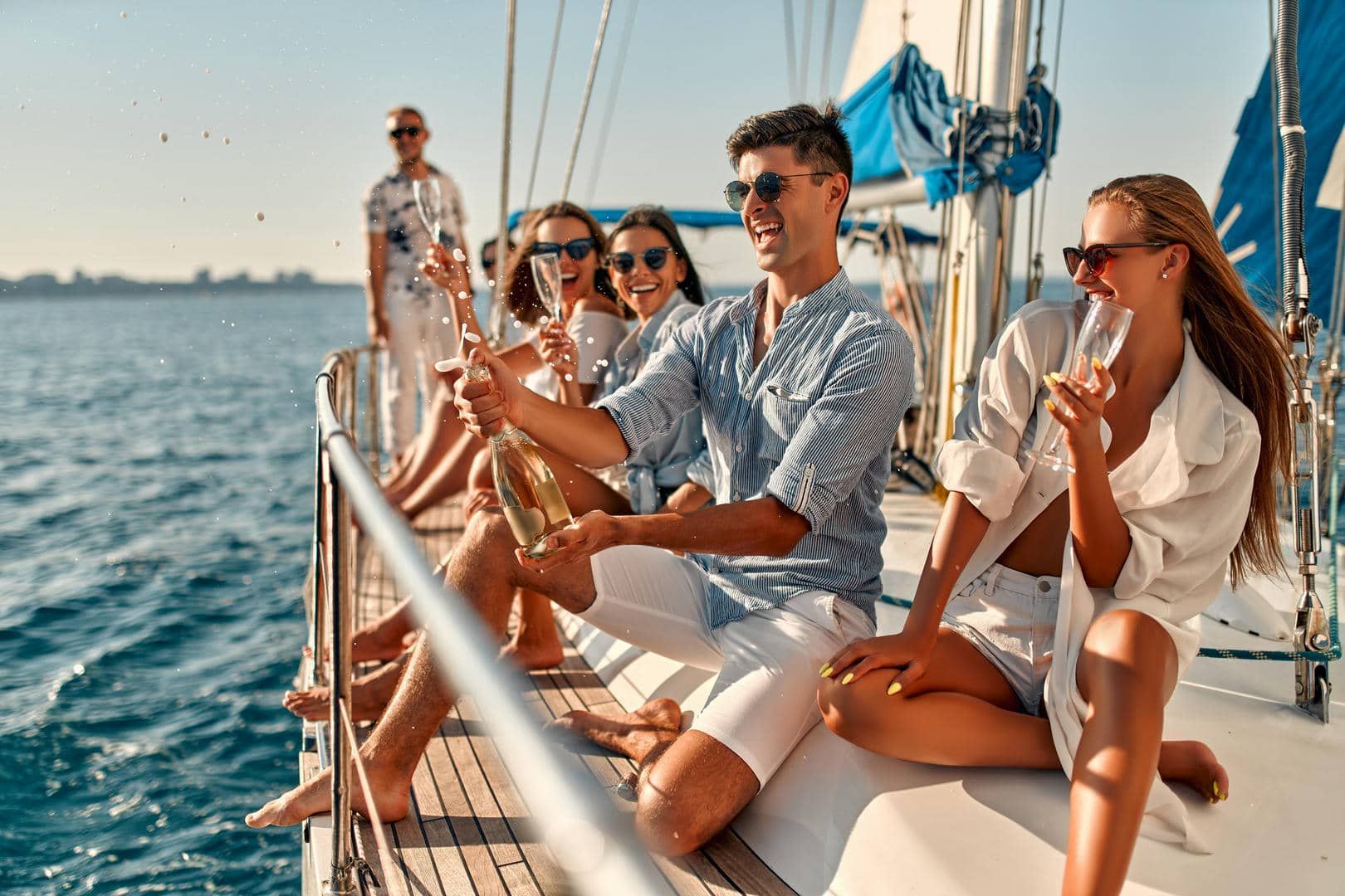 A group of people are sitting on a boat toasting with champagne.