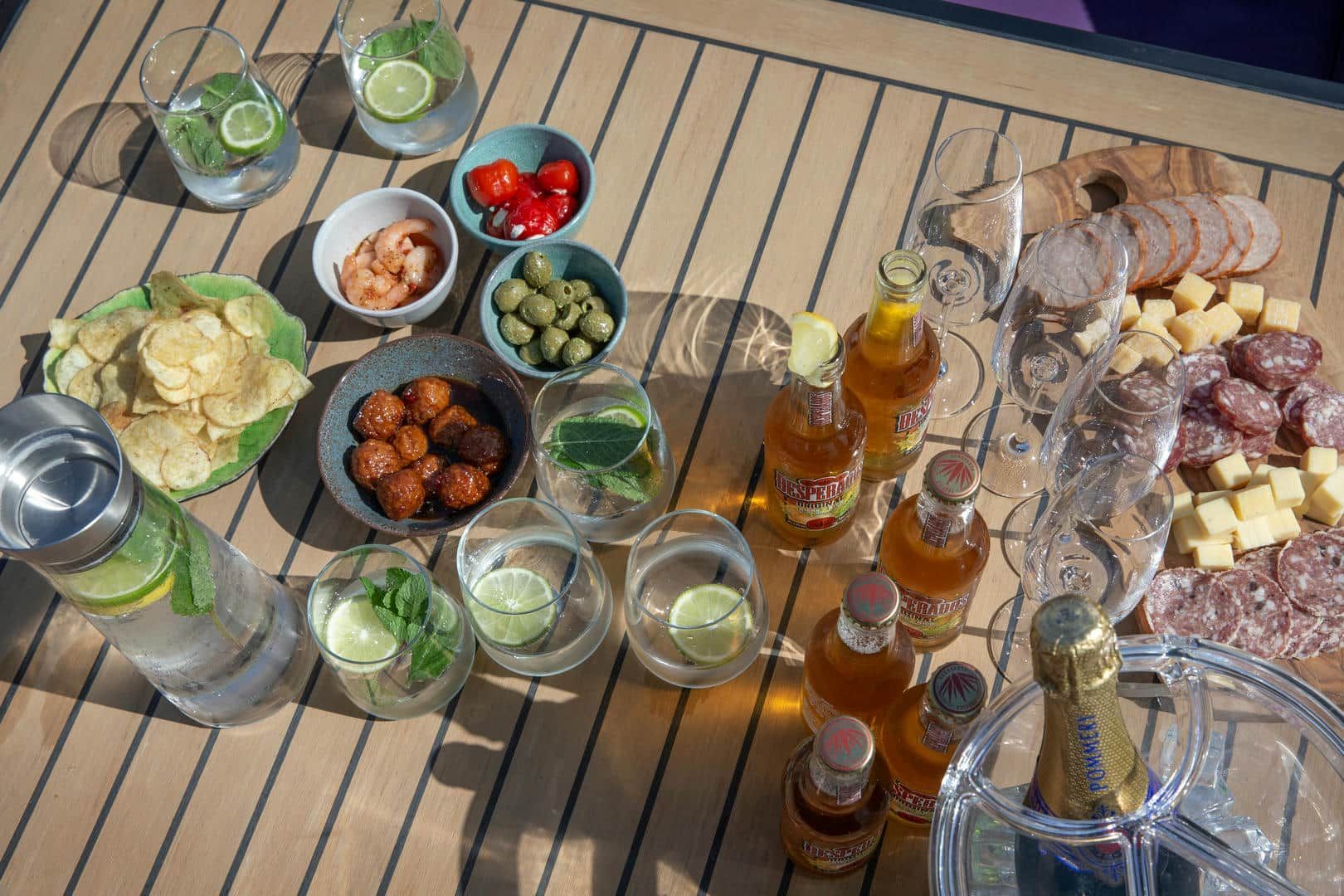 A wooden table topped with a variety of food and drinks.
