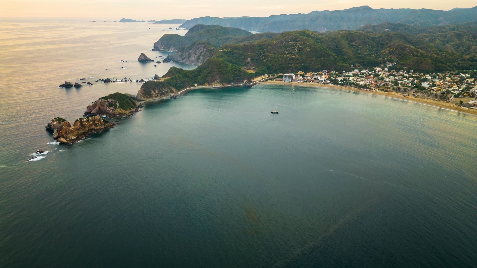 A man and a woman are standing on a boat watching a humpback whale in the ocean.
