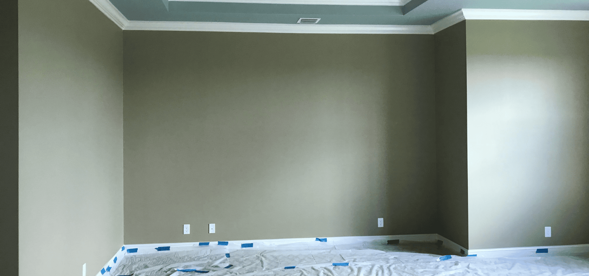 Bedroom painted army green, drop cloth covering the floor