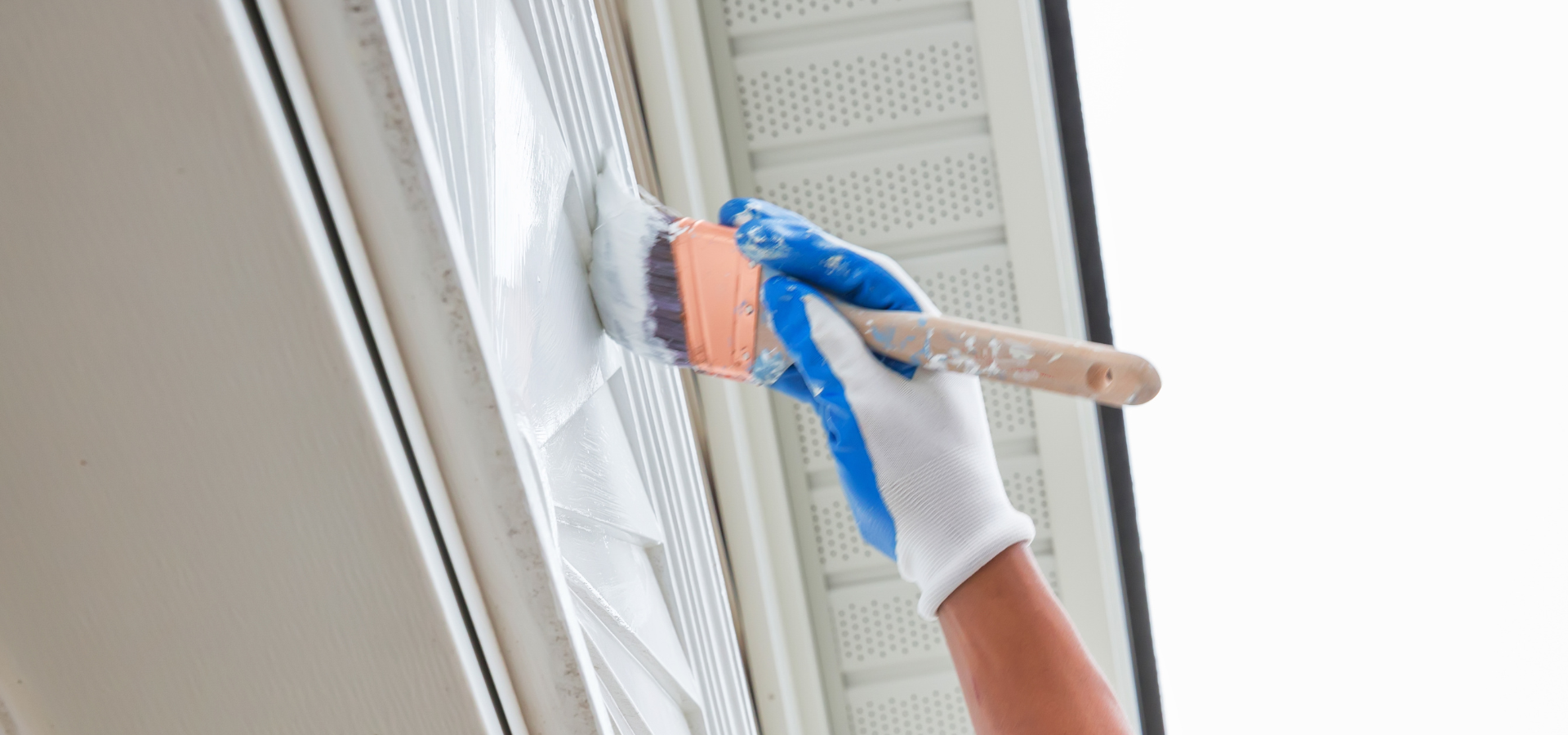 Homeowner painting his home's exterior before listing it for sale in Raleigh, NC