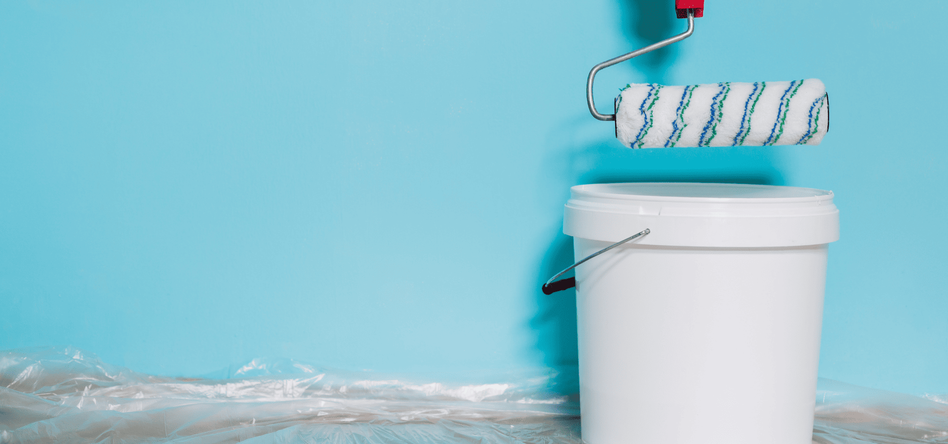 Dipping a roller into blue interior wall paint