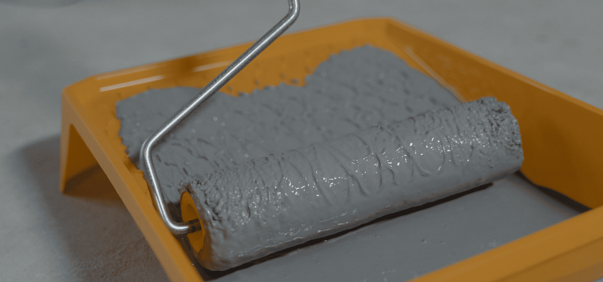 Gray paint in a liner on a paint tray