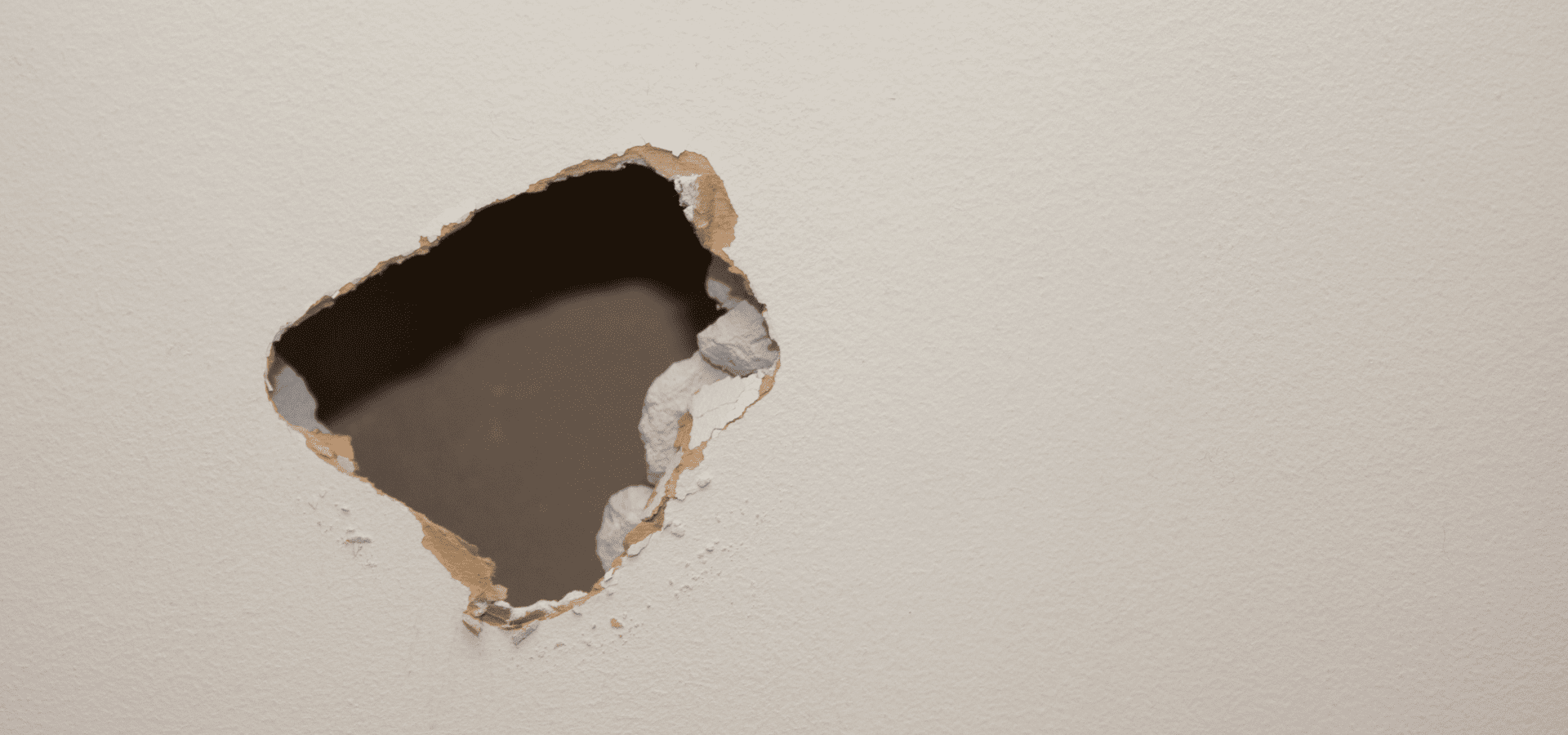A large hole in drywall that requires professional attention