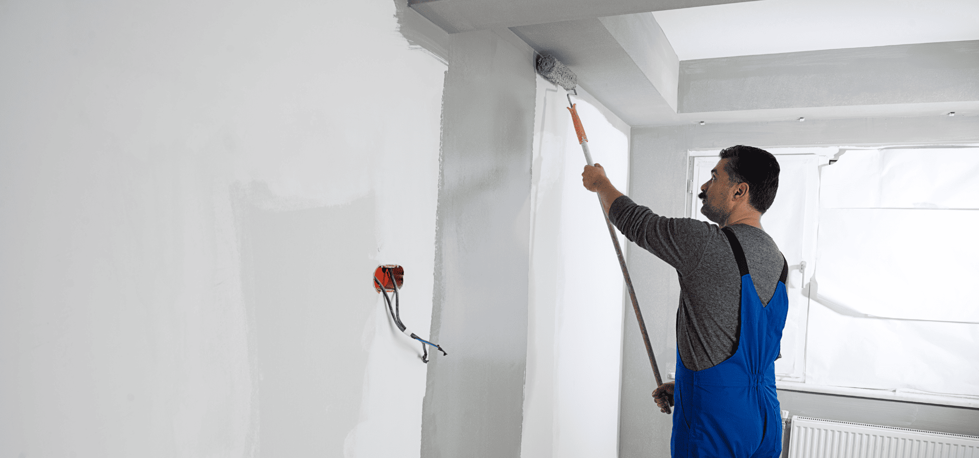 A painter from Renewed Walls Painting painting the interior of a client's home to prepare it for selling in Raleigh