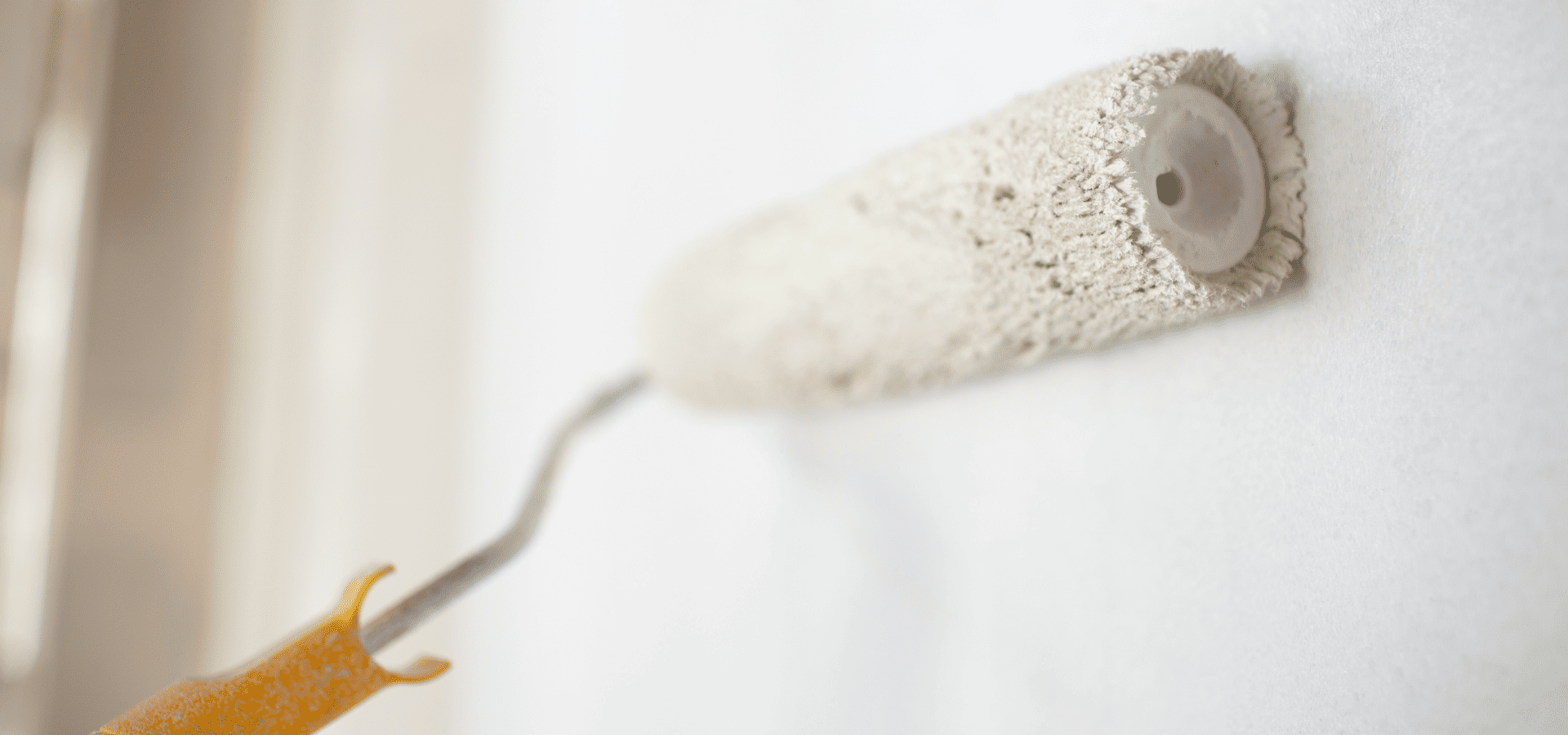 Painting the walls of a living room white with a roller