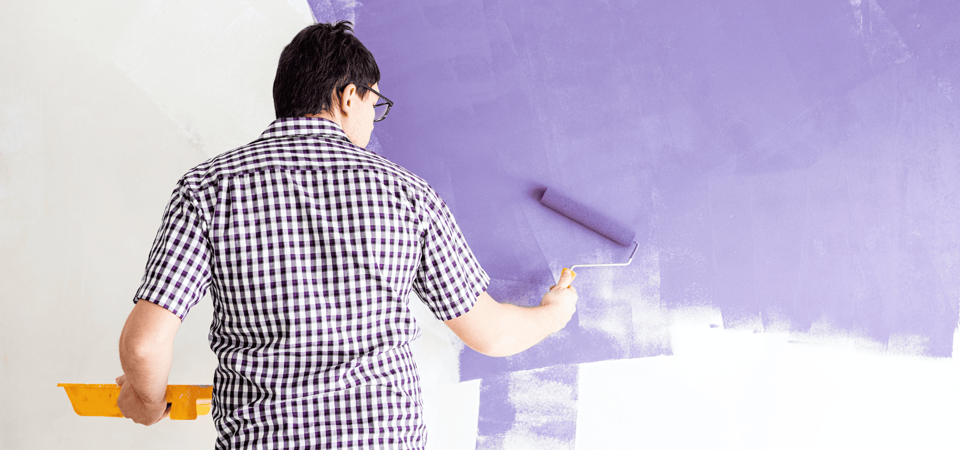 Homeowner painting home walls purple during early winter