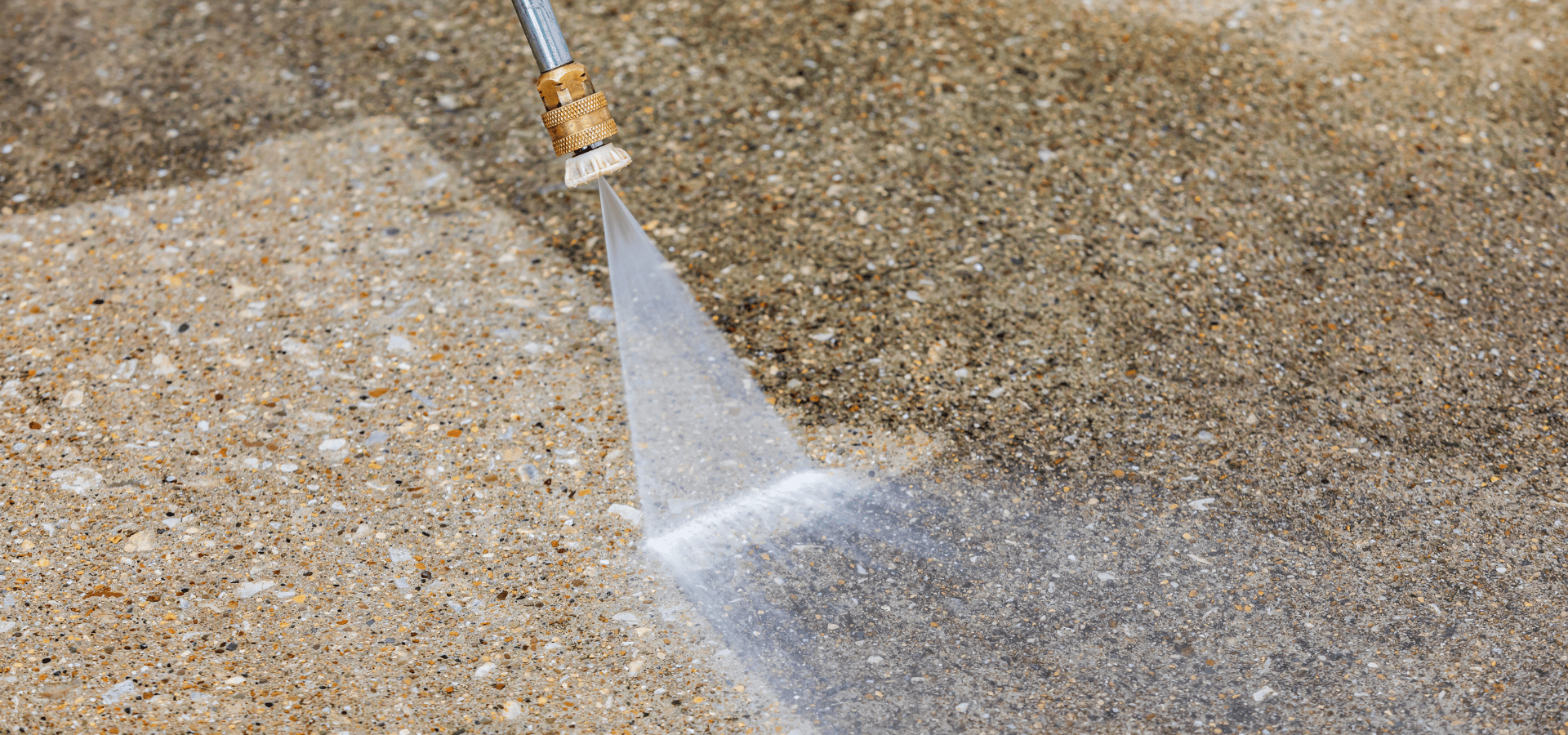 Pressure washing a dirty concrete driveway before coating