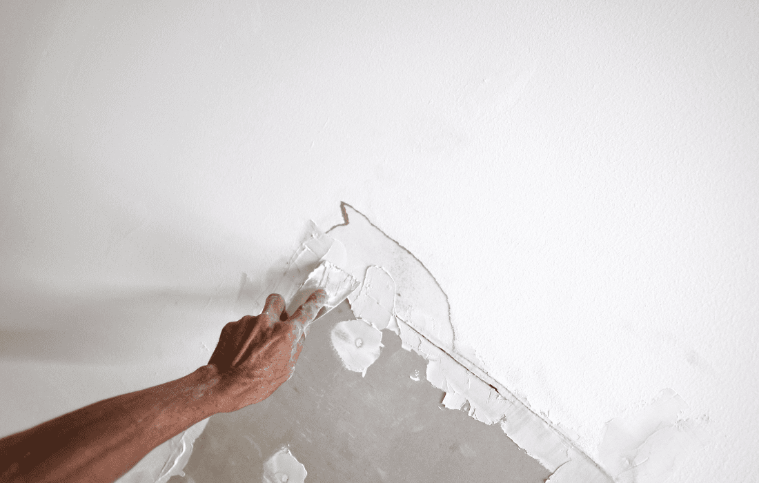 A worker from Renewed Walls Painting repairing ceiling drywall damaged by water