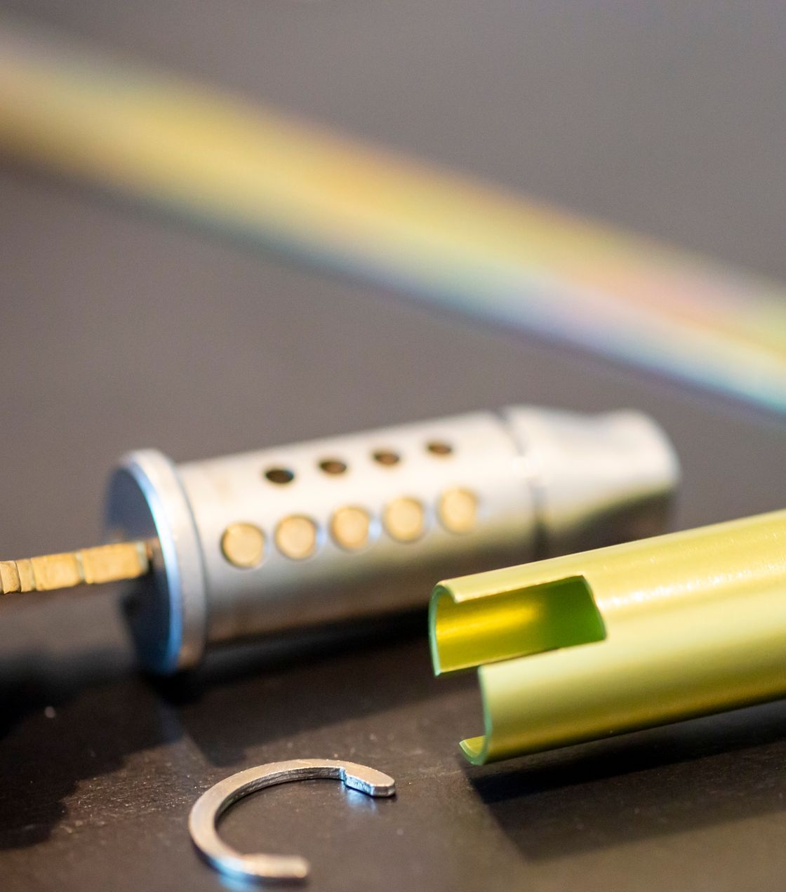 A close up of a pen with a rainbow in the background