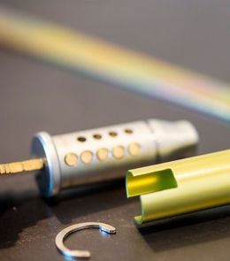 A close up of a pen with a rainbow in the background