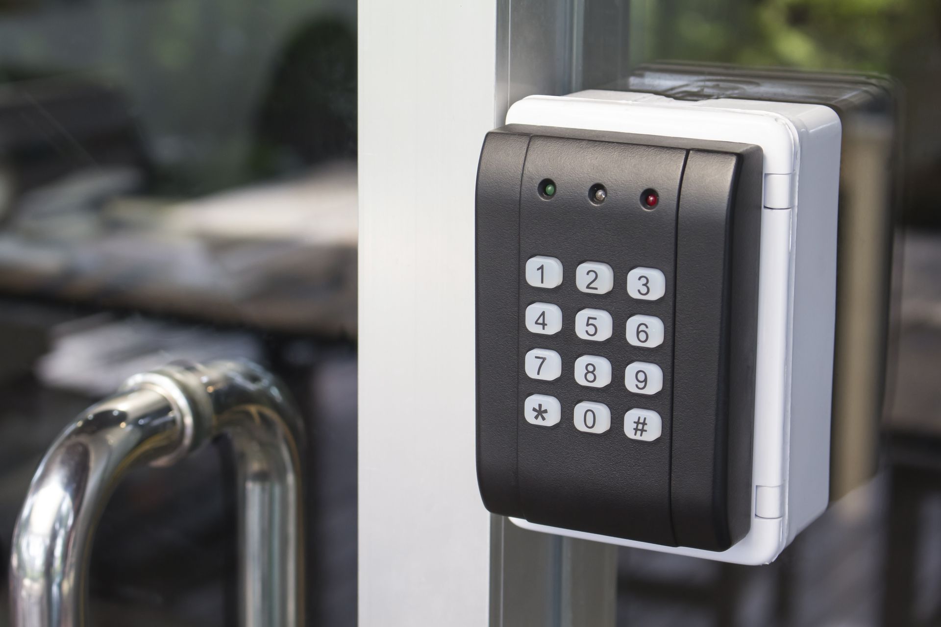 A close up of a keypad on a glass door.