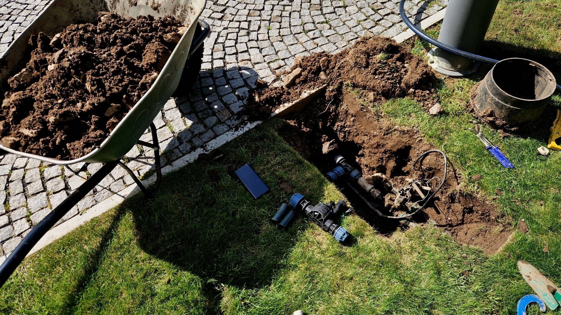 A wheelbarrow filled with dirt is sitting on top of a lush green lawn.