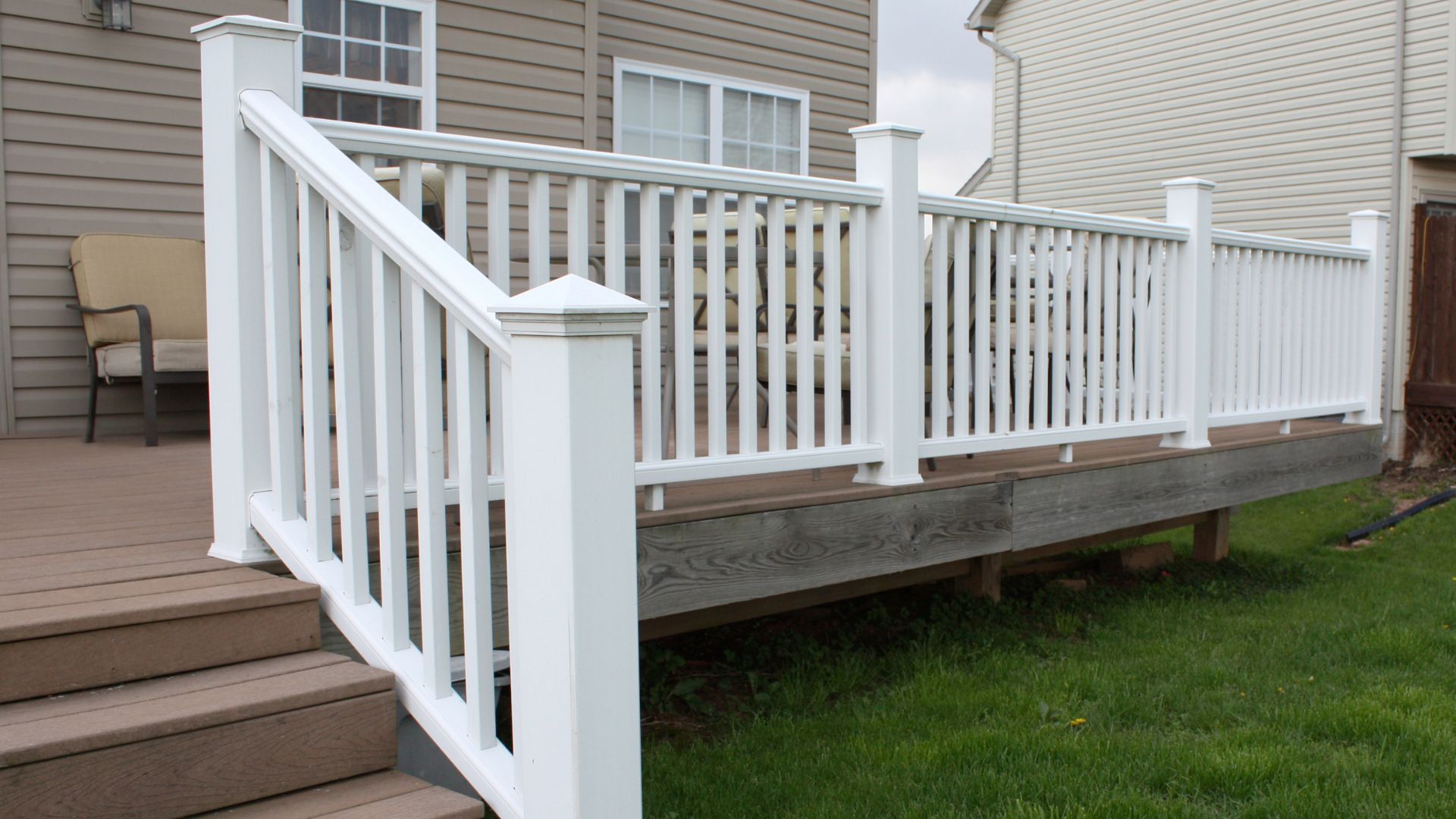 Well-maintained deck with white railing and grey planks against a beige house in Stockton, CA.