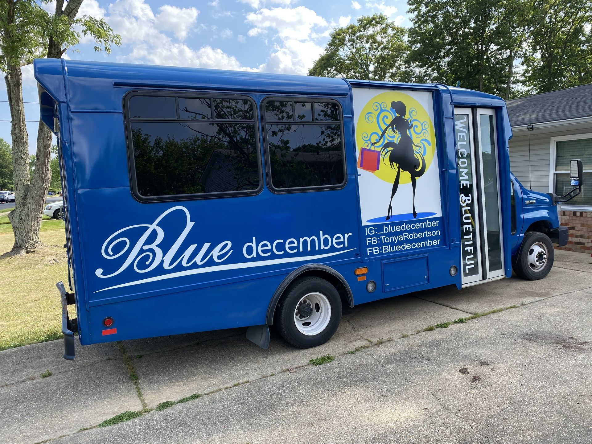 White Sign Depot pickup truck parked on brick, with commercial graphics, residential background.