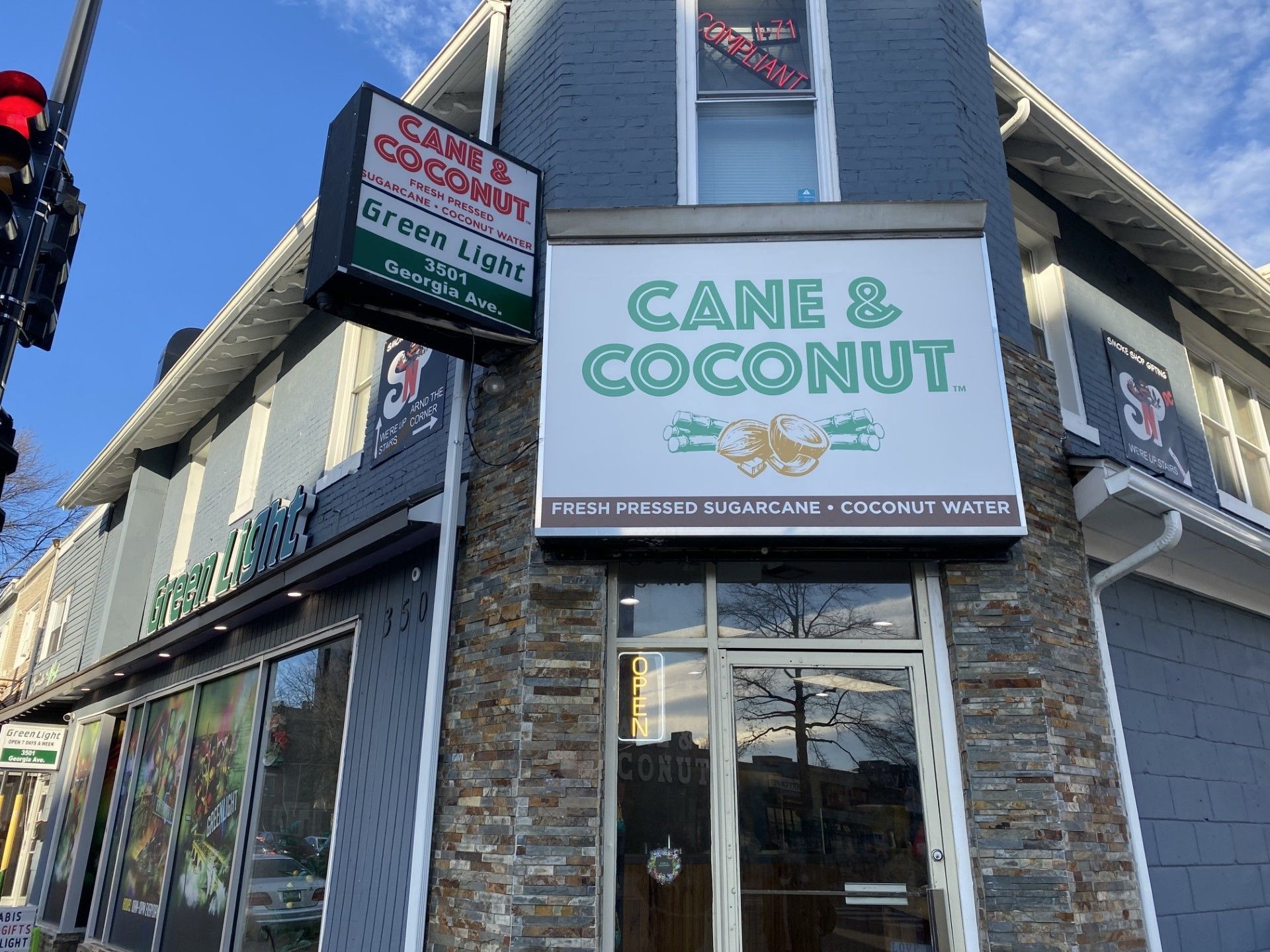 Cane & Coconut storefront with a sign advertising fresh pressed sugarcane and coconut water.