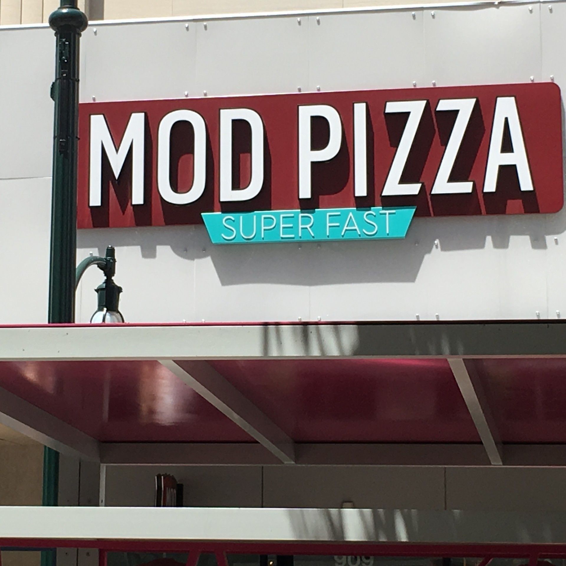 MOD PIZZA restaurant sign with red and white letters, teal accent, and 