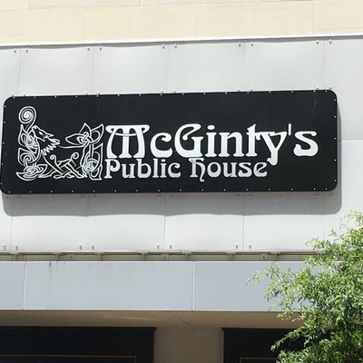 Sign for McGinty's Public House, white text on a black background, with Celtic knotwork design.
