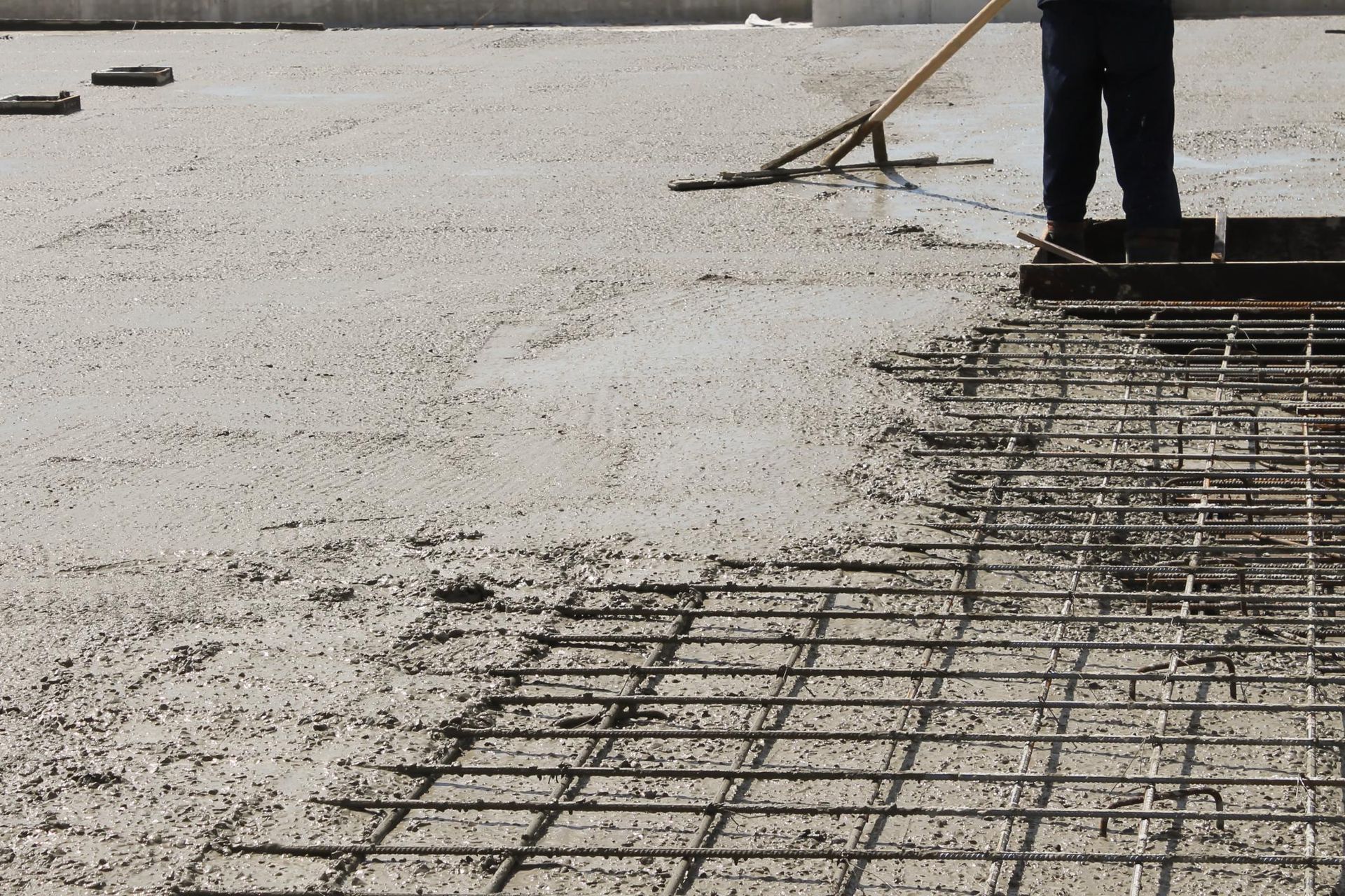 A man is brushing a concrete surface with a broom