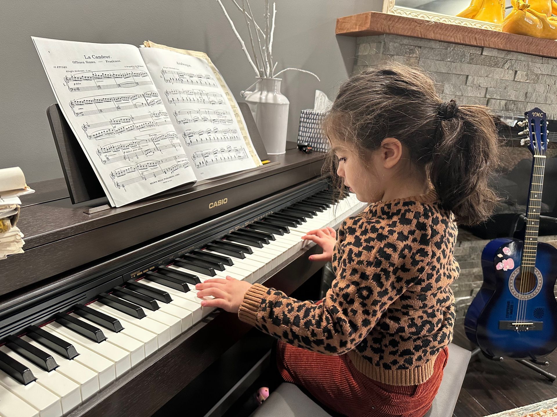 A seated child playing a piano.