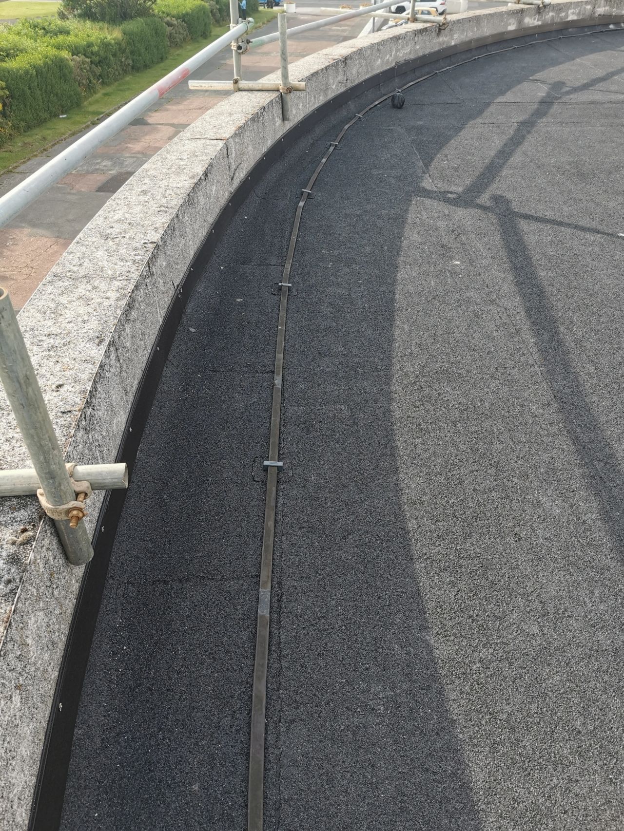 Gray circular structure with a dark-colored interior and a concrete rim, viewed from above.