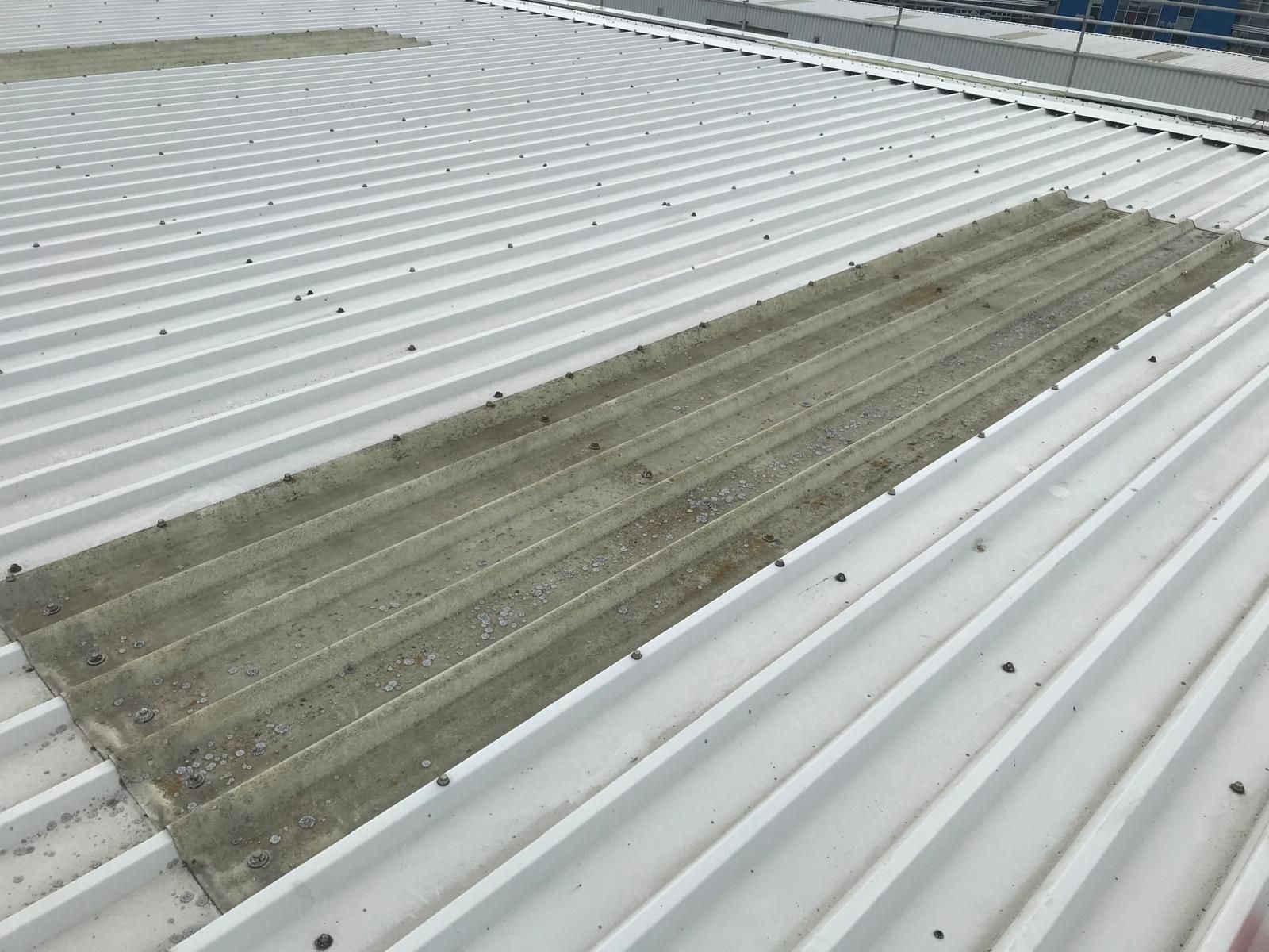 White metal roof with three gray rectangular patches of sealant.